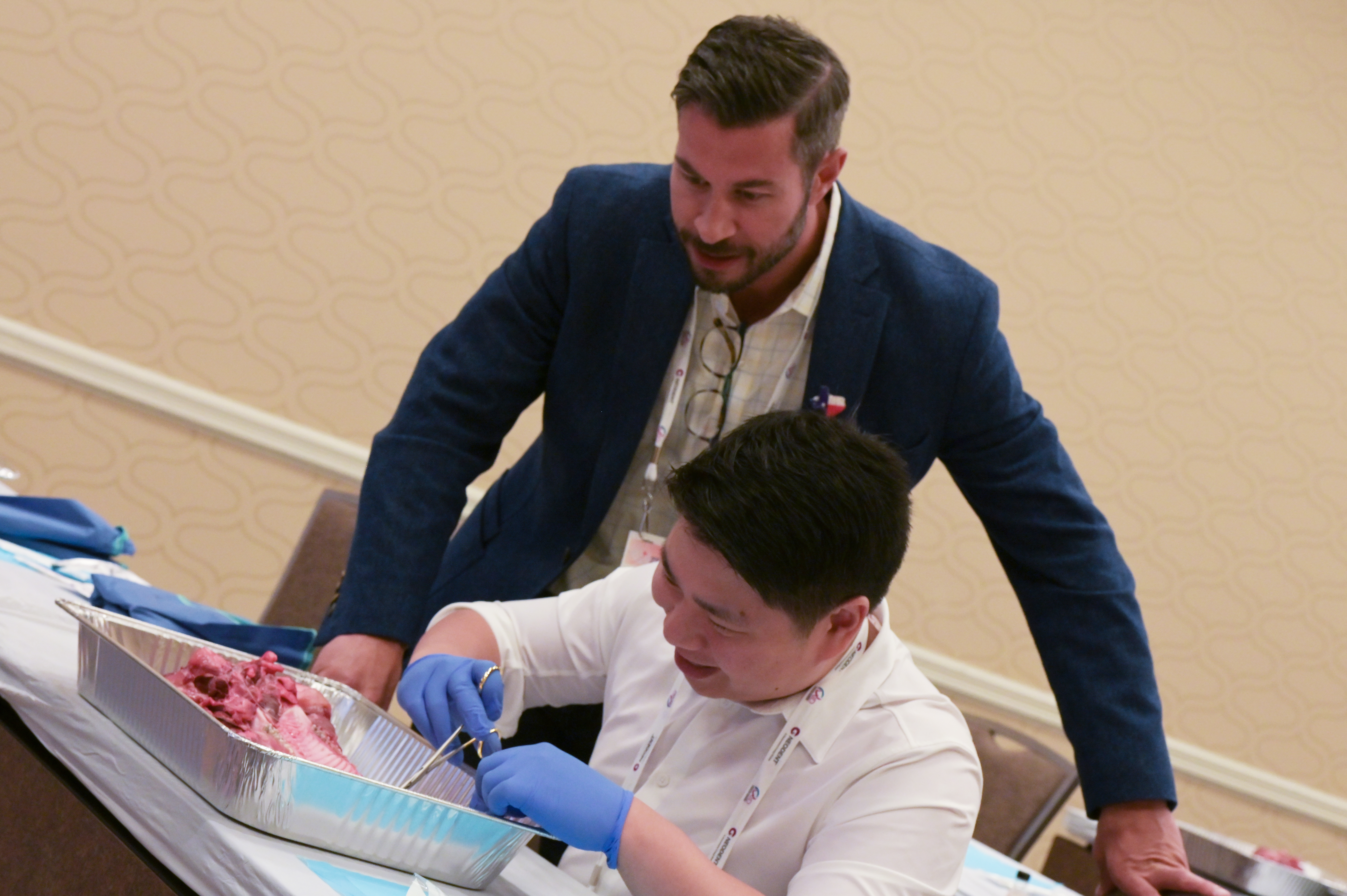 Photo of two men dissecting flesh in aluminum.