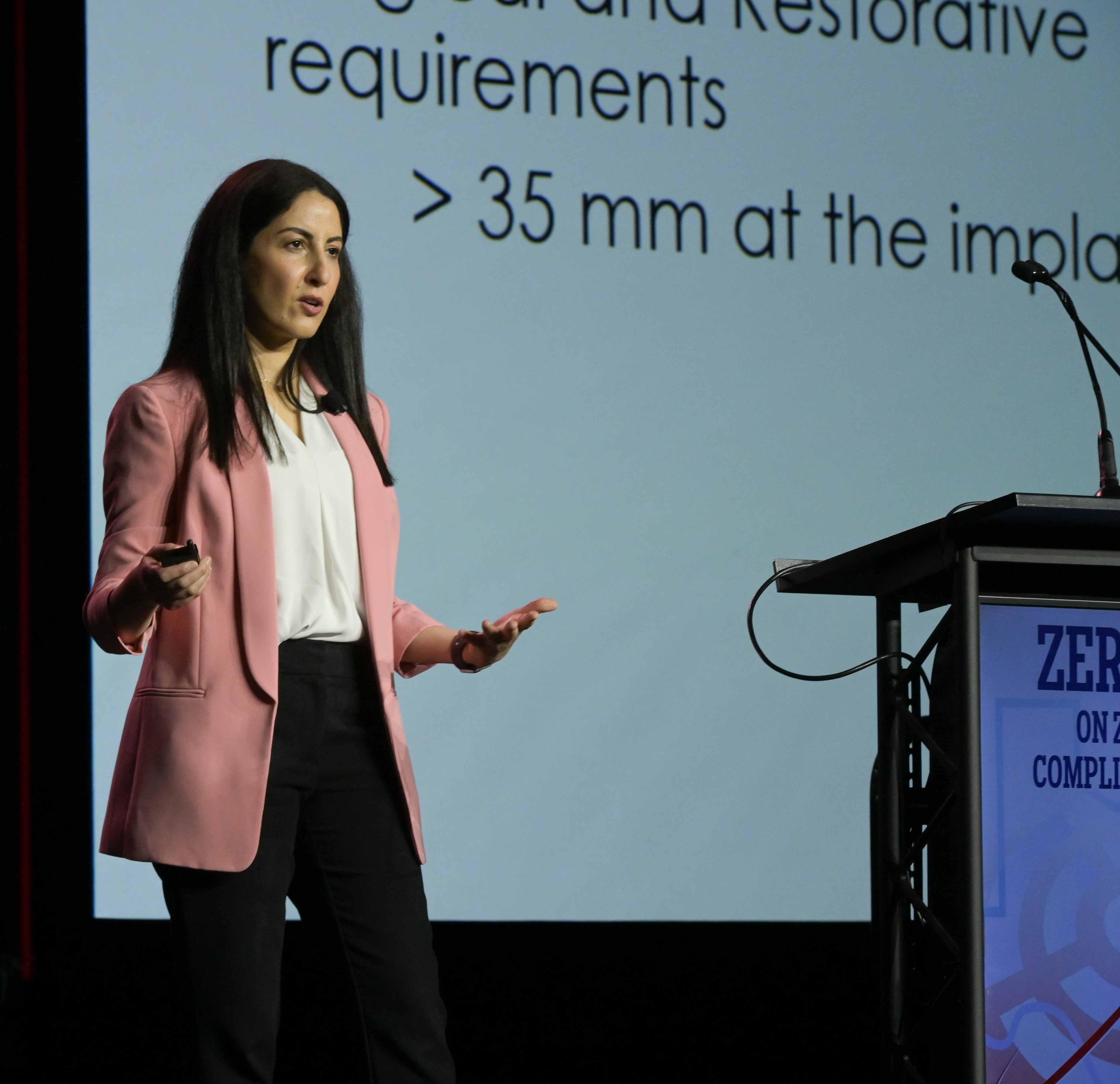 Image of a woman speaking on a stage