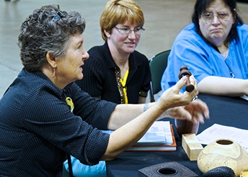 Betty Scarpino explains her turned rattle with captured rings to the group