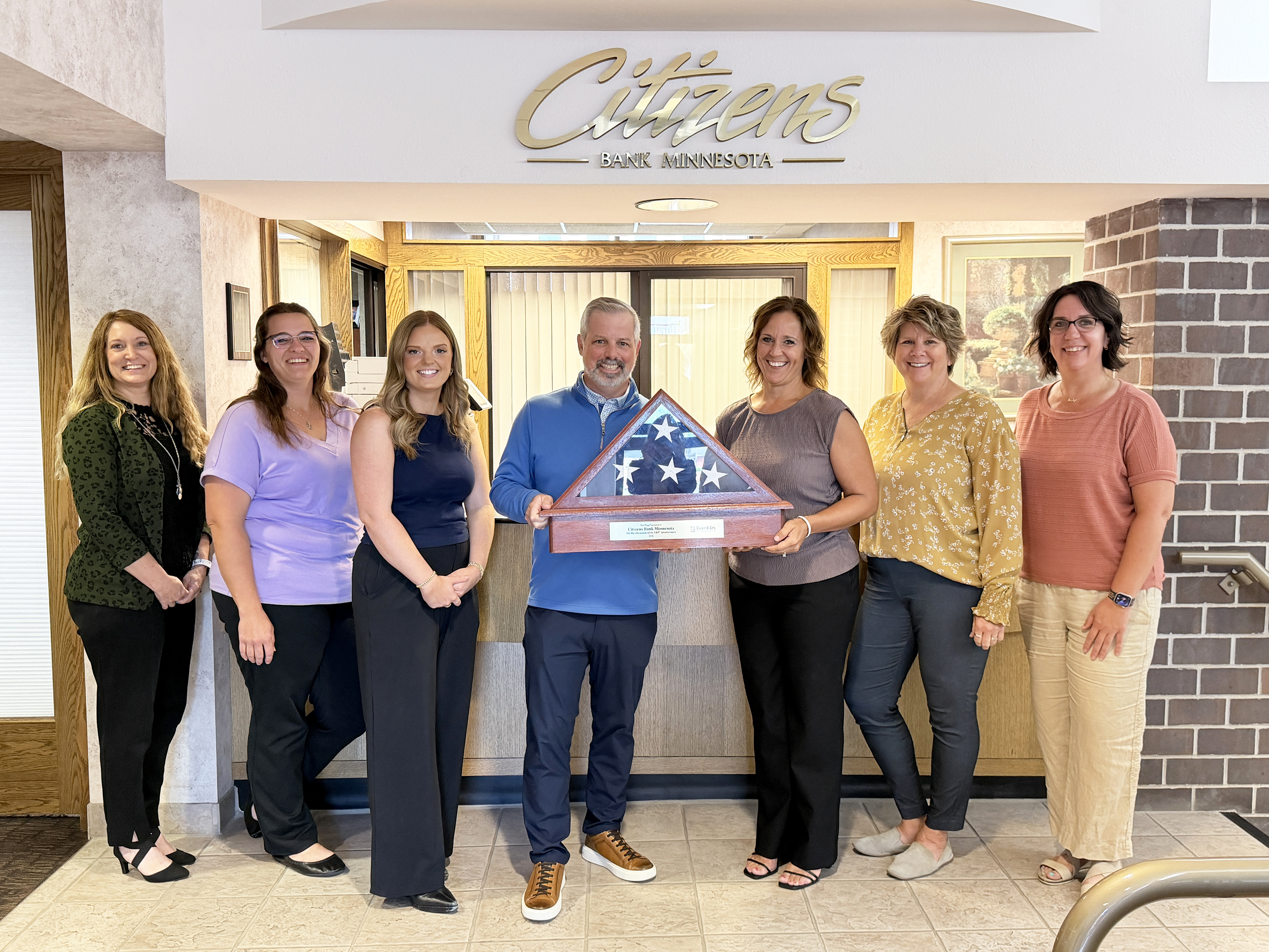 Citizens Bank Minnesota receives a milestone flag recognizing its 150th anniversary.