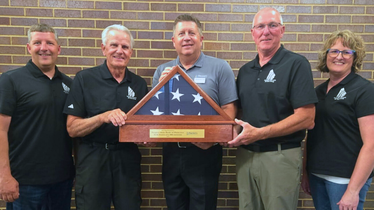 Peoples State Bank of Plainview receives a milestone flag recognizing its 100th anniversary.
