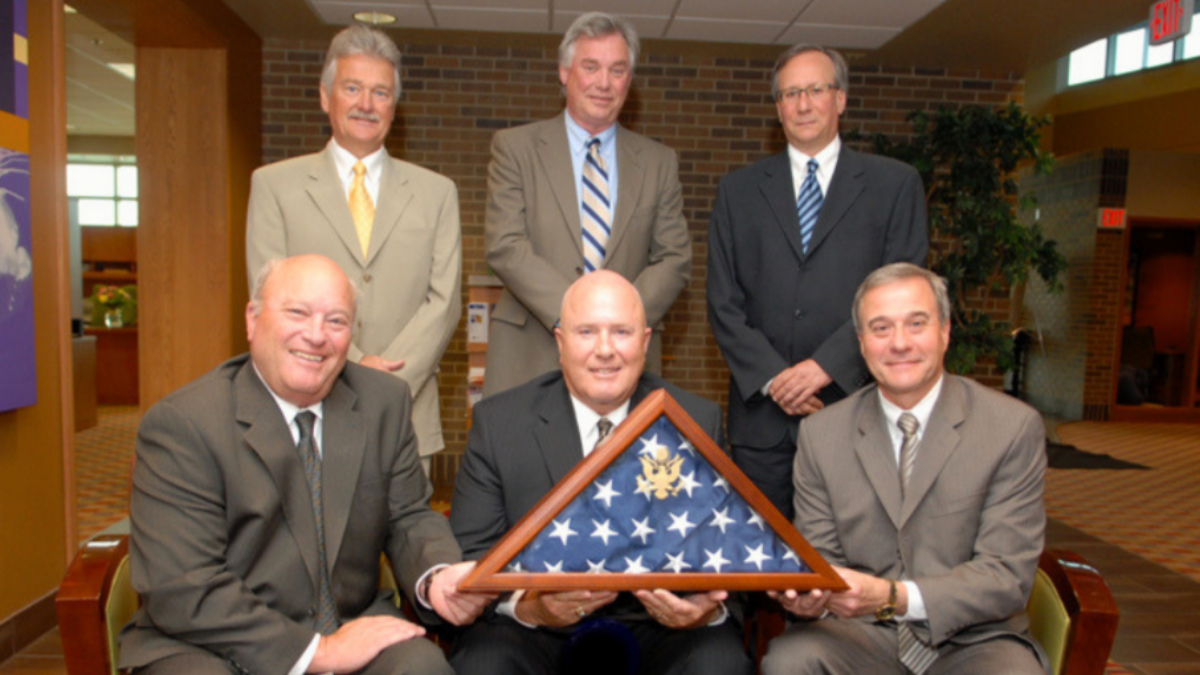 Security Bank USA receives a milestone flag recognizing its 100th anniversary.
