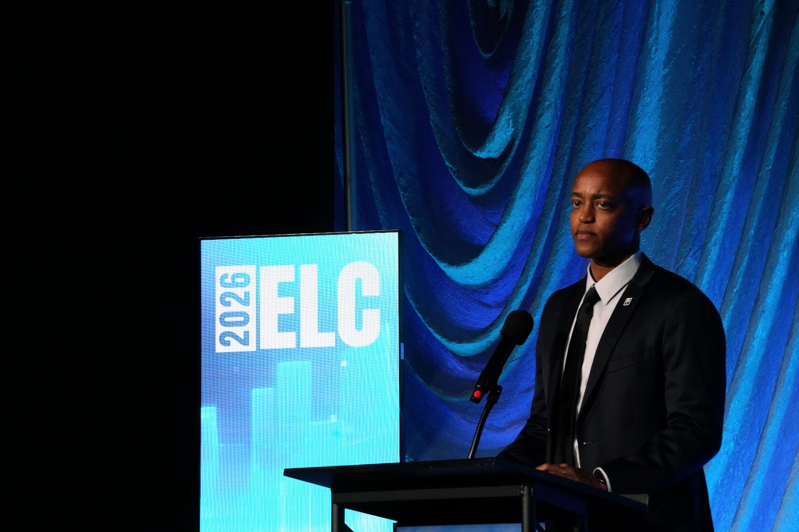 King County Executive Girmay Zahilay speaks from the main-stage podium beside the 2026 ELC sign
