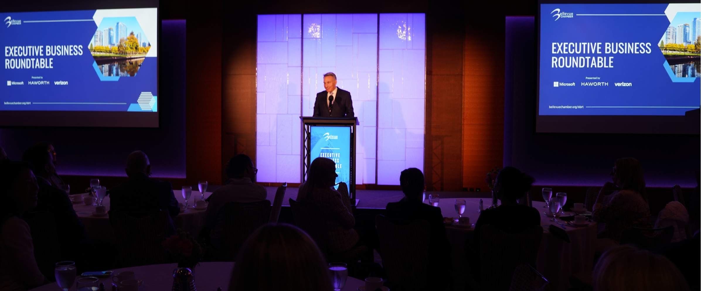A speaker at the podium of a Bellevue Chamber ballroom event