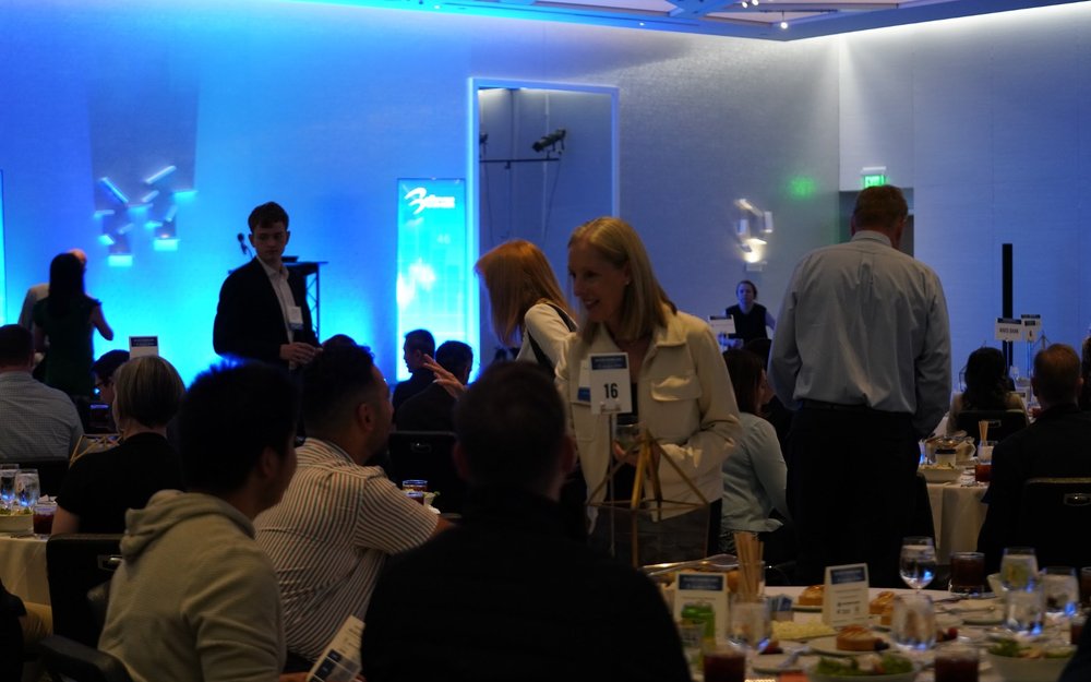 Guests finding their seats at round tables before a Chamber Lunch