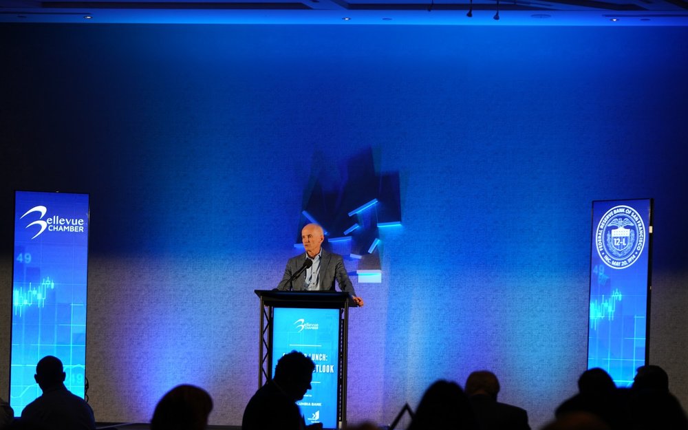 A speaker at the podium with the audience at a Chamber Lunch