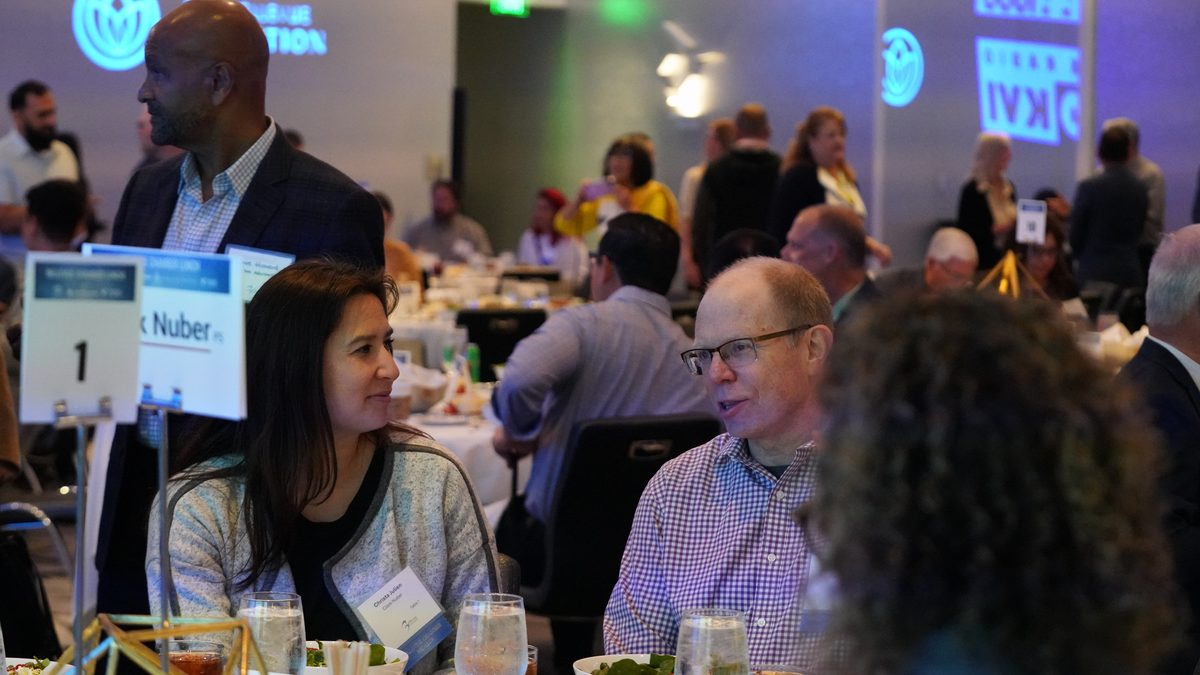Guests in conversation over lunch at round tables during a Chamber Lunch