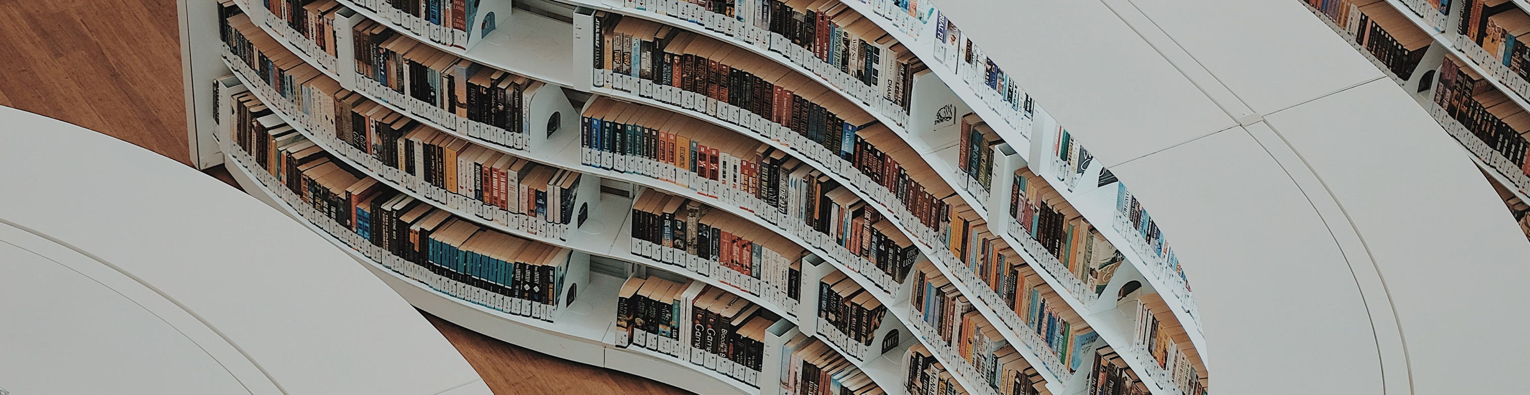 A bird's-eye view of a library. The shelves are white and organically shaped.