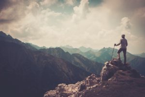 Woman hiker standing on top of a mountain