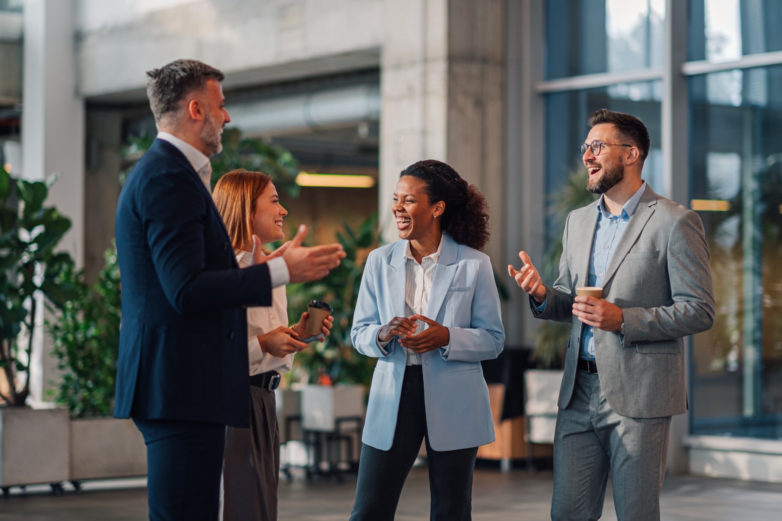 Four professionals talking and smiling