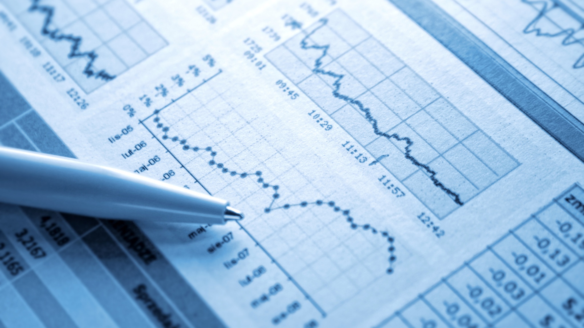 Blue-toned financial chart and spreadsheet with a pen in the foreground.