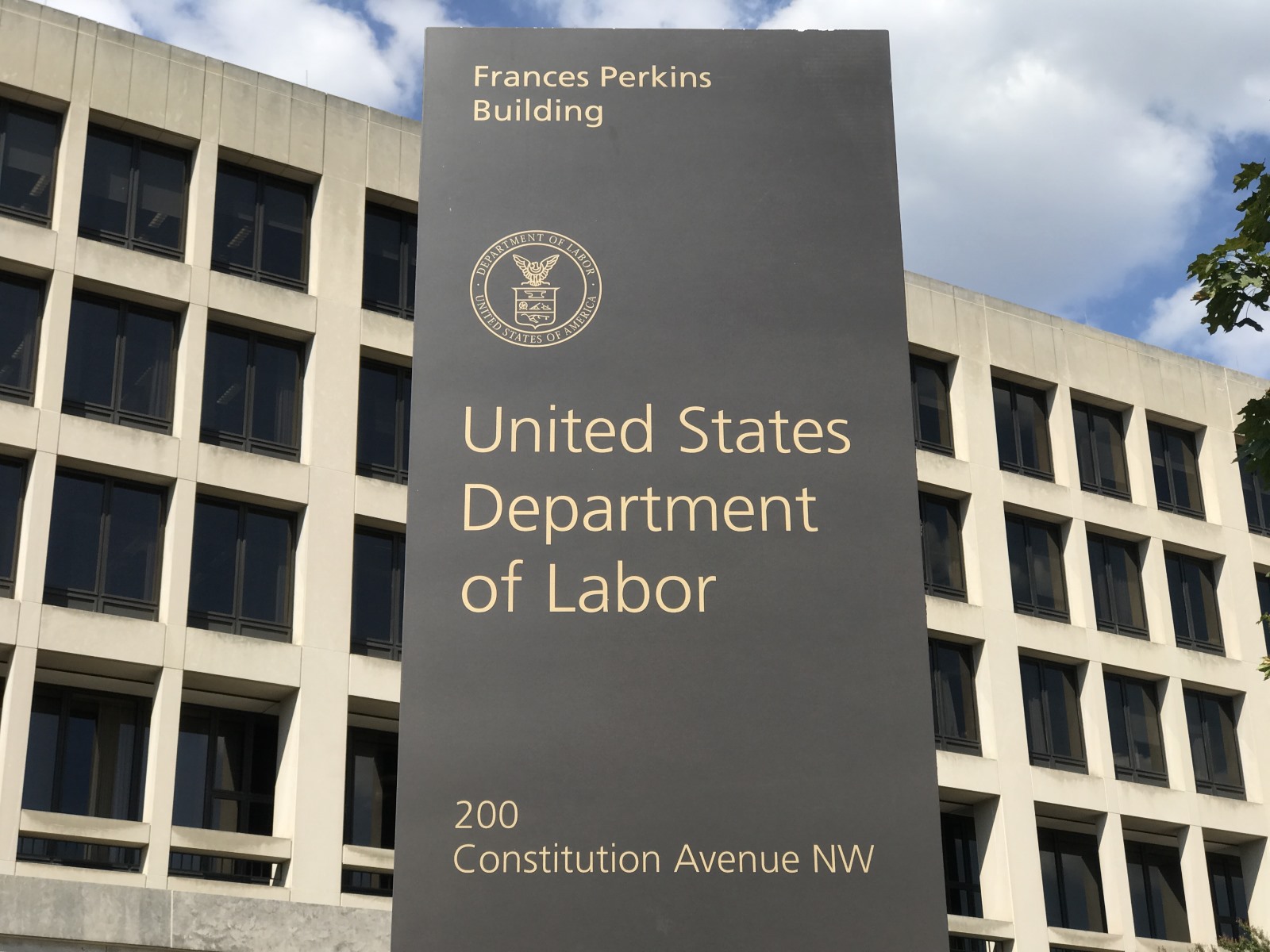 Photo of the sign for the United States Department of Labor's Frances Perkins Building with the building itself in the background