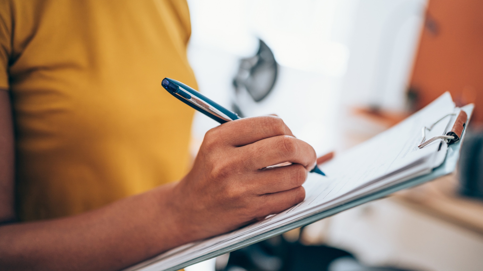 Hand writing on a clipboard.
