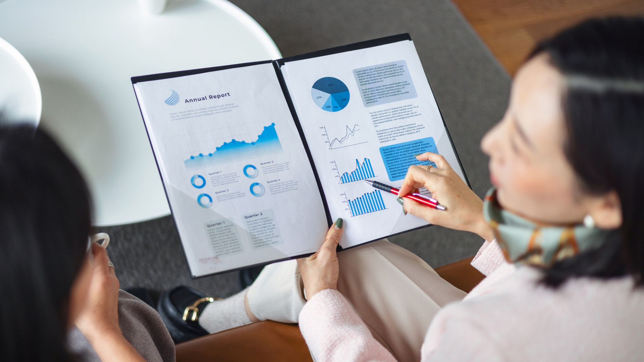 Woman reviewing printed charts and graphs at a desk.