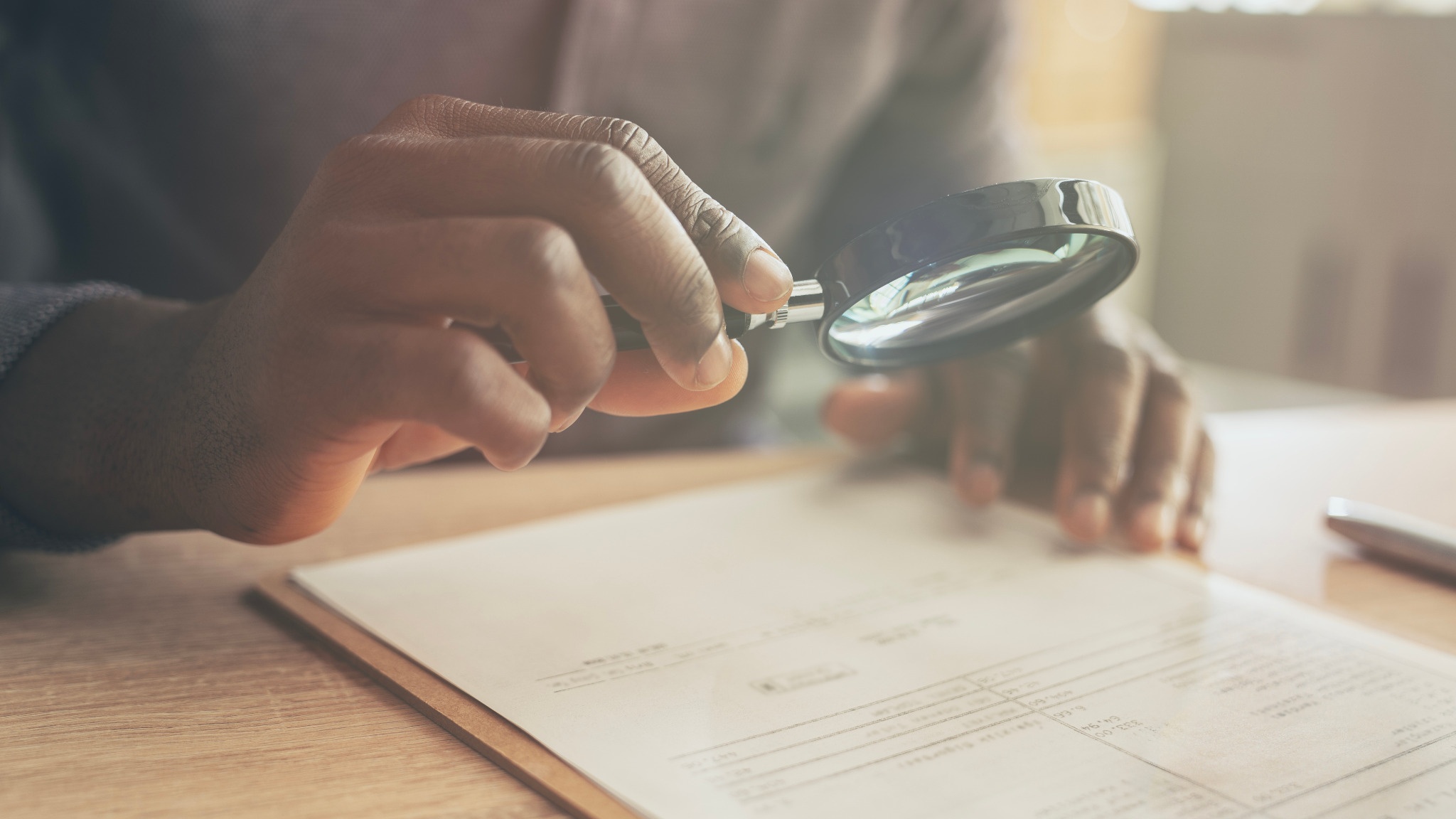 Close up of a hand holding a magnifying glass