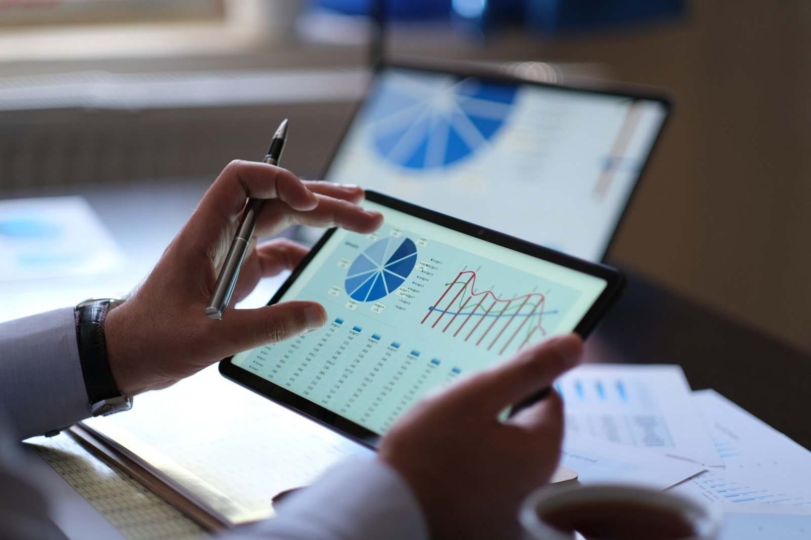 Investment professional reviewing private market performance data on a tablet