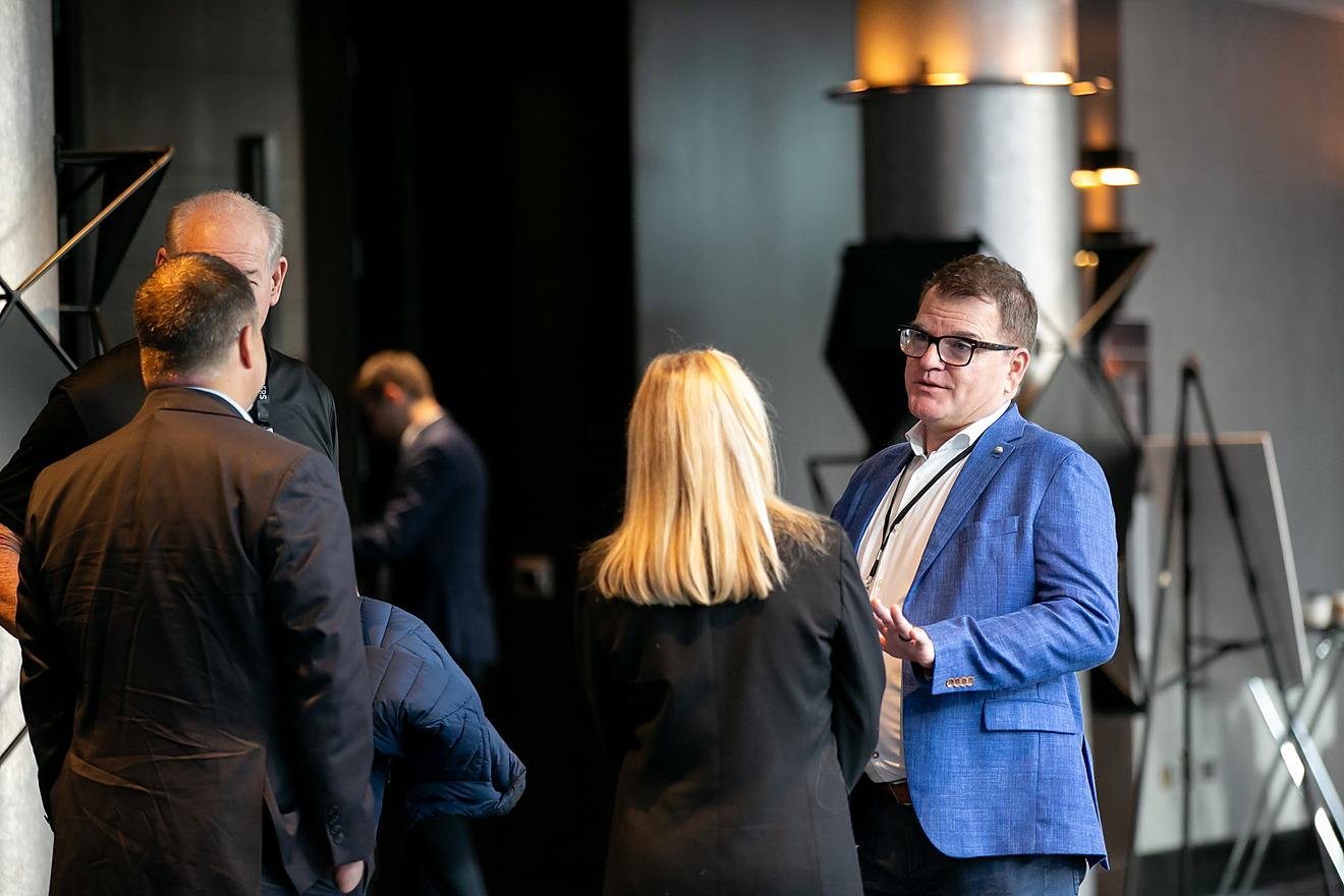 Four attendees standing in a circle discussing a session