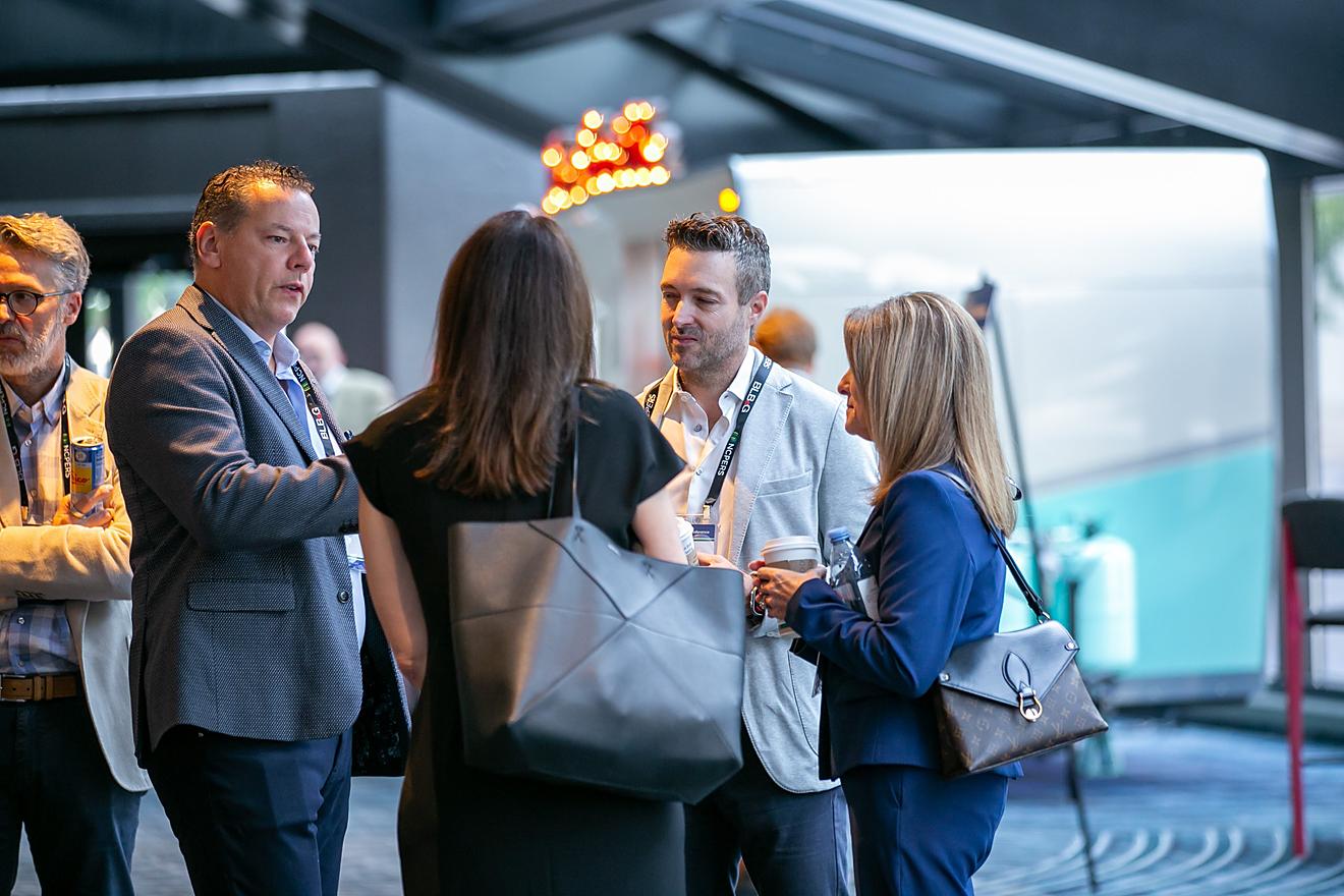 Four attendees standing in a circle speaking to one another