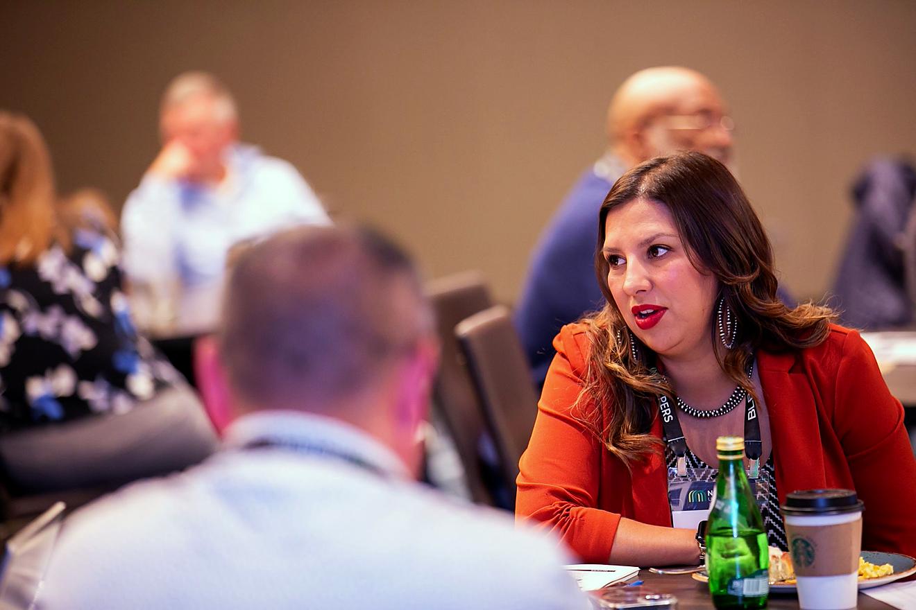 Attendees sitting at a table during a session