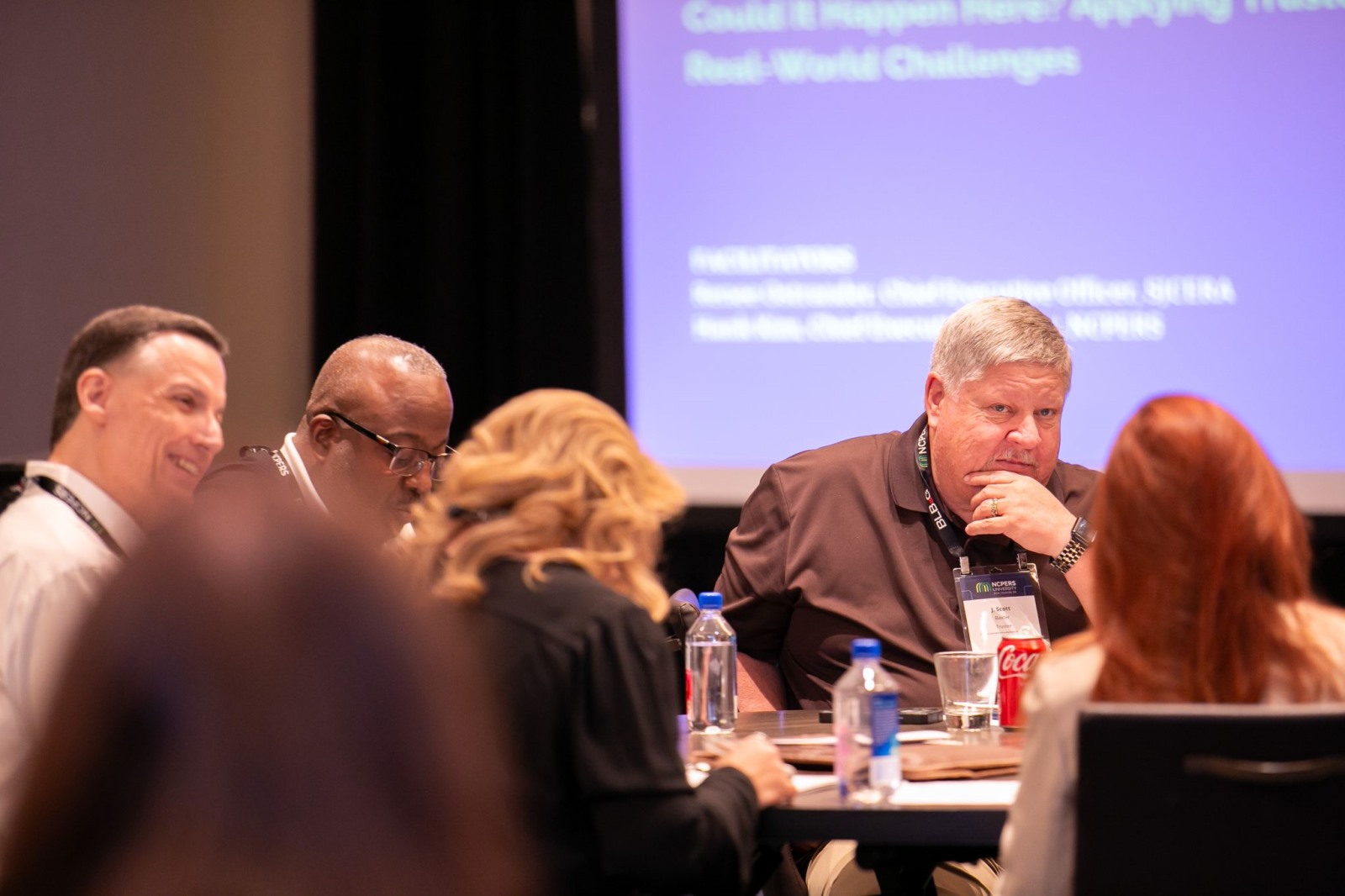 Small group of attendees speaking at a table