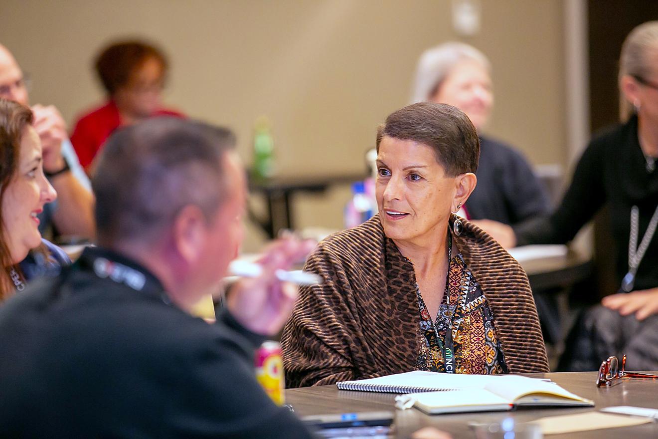 Attendees sitting around a table discussing a session