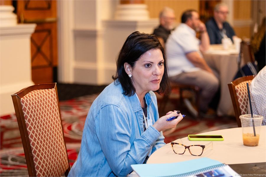 Attendee at a table speaking with a colleague