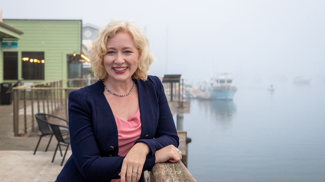 Amy smiling at a camera in the fog on Morro Bay