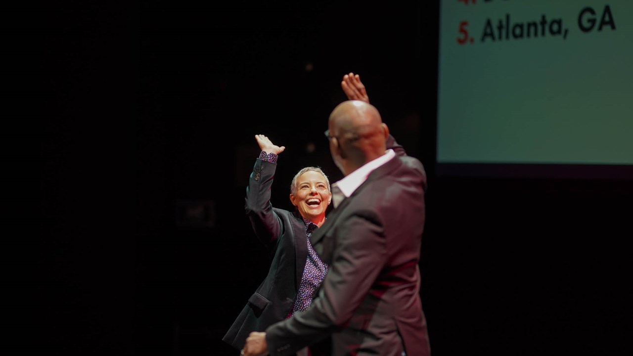 Amy Climer giving a high 5 to another presenter on stage