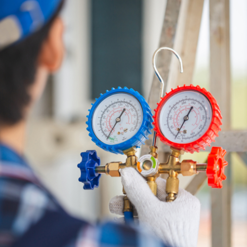 Man out of focus holding red and blue HVAC tool