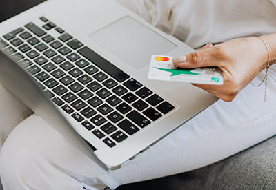 A customer shopping online with their laptop and credit card