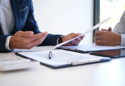 Two people reviewing workers' compensation papers