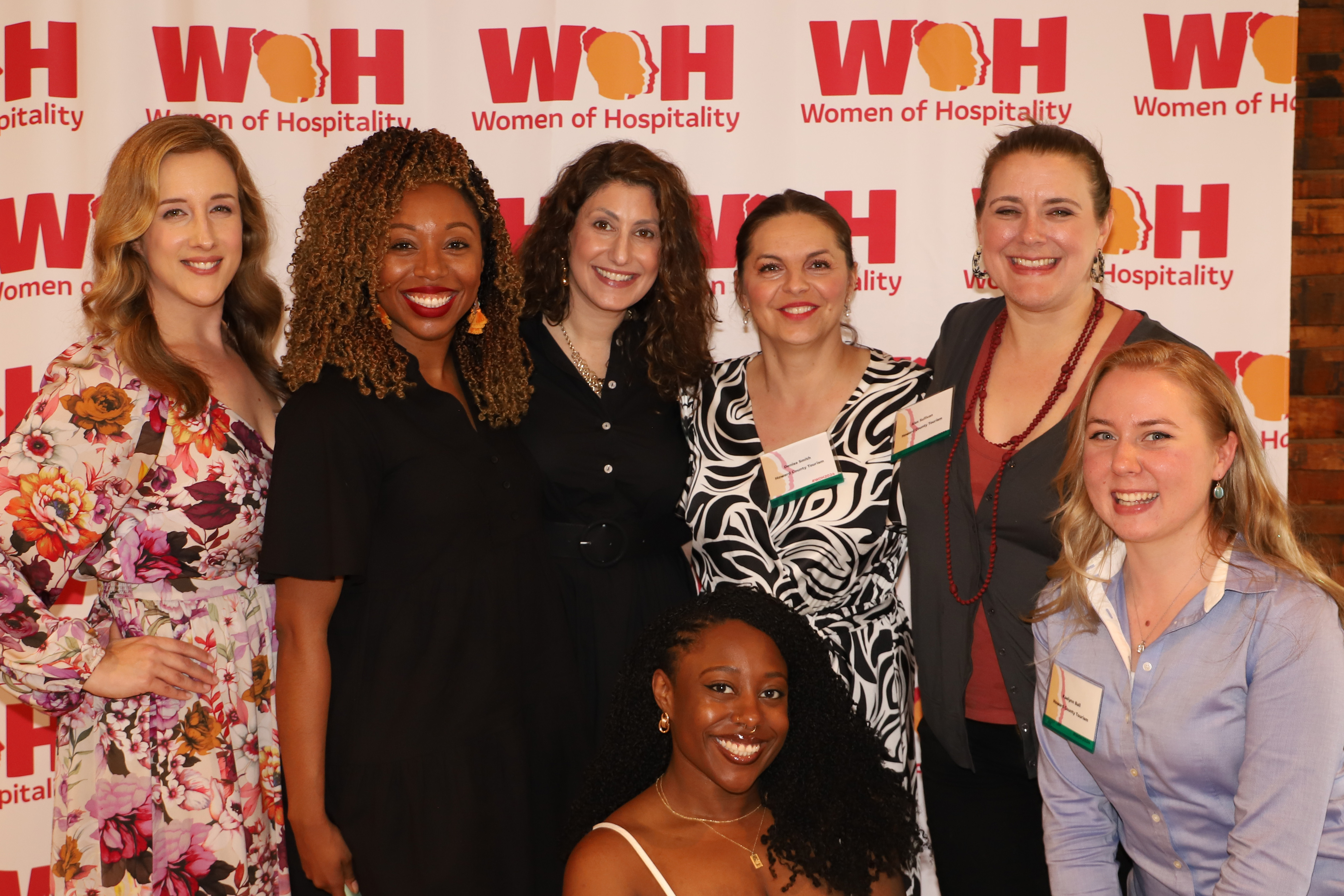 A group of women poste in front of the WoH backdrop