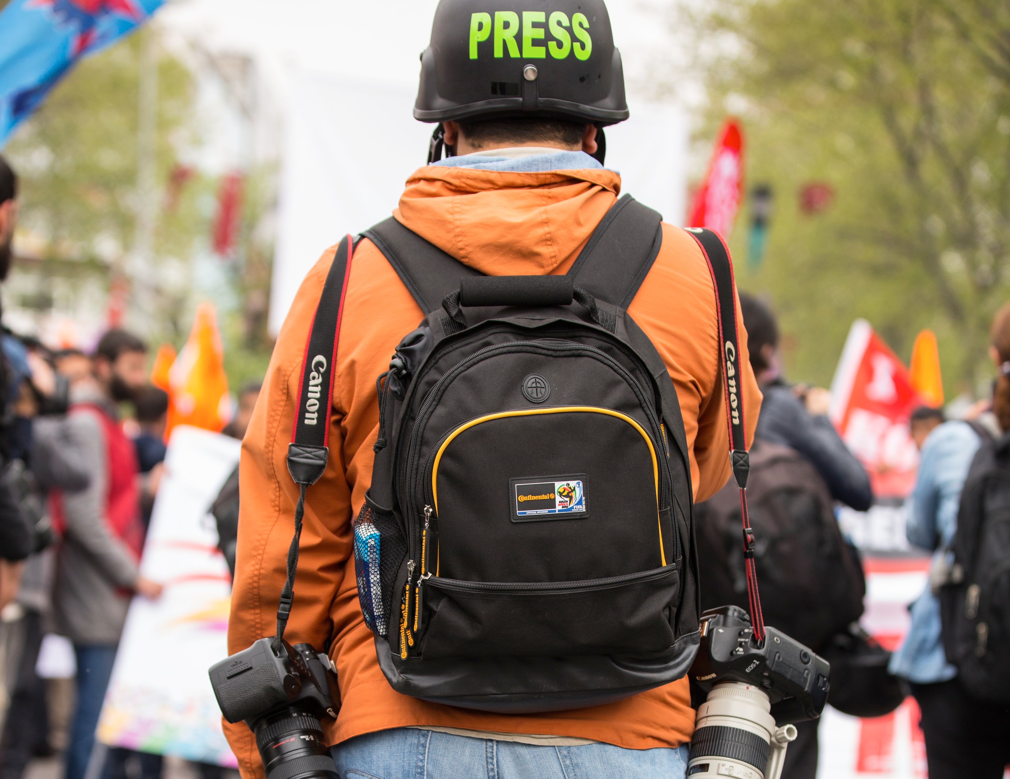 press person with backpack and helmet
