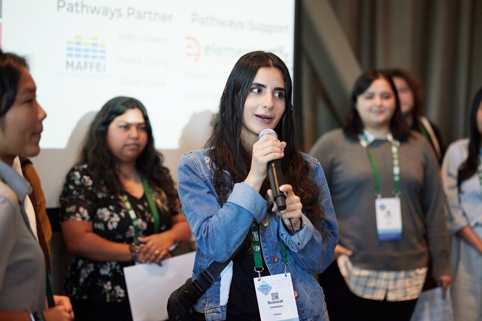 A cohort member speaks into a microphone during a Pathways workshop
