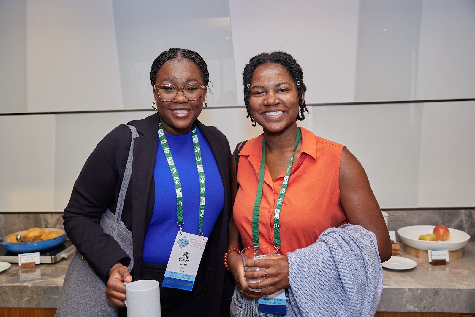 Two cohort members smiling together at a reception